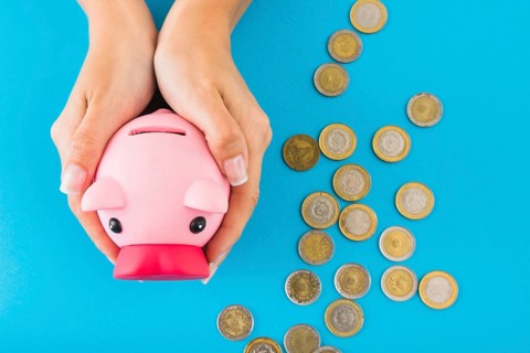Hands holding piggy bank table with coins