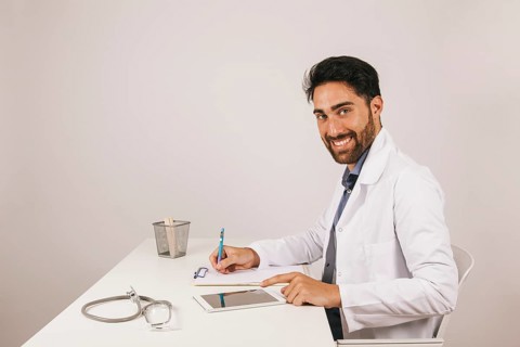 Happy doctor with tablet office