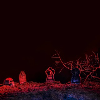 Headstones skull illuminated by red light ground