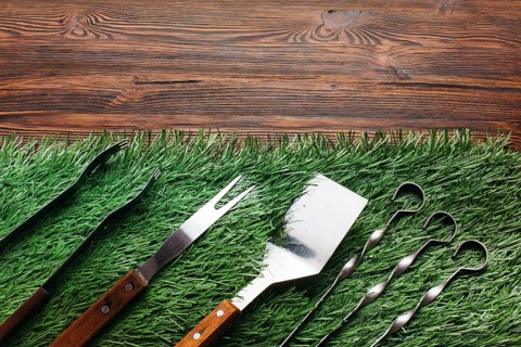High angle view barbecue utensil set green mat wooden table