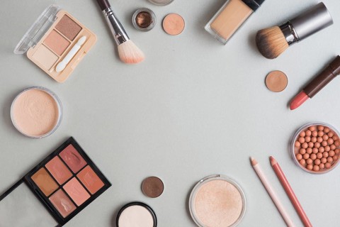High angle view make up kits forming circular shape white backdrop