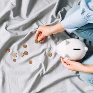 Human hand holding coins piggybank