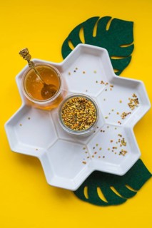 Jar bee pollens honey white tray yellow background