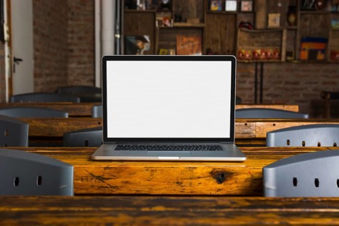 Laptop with white display screen wooden table caf