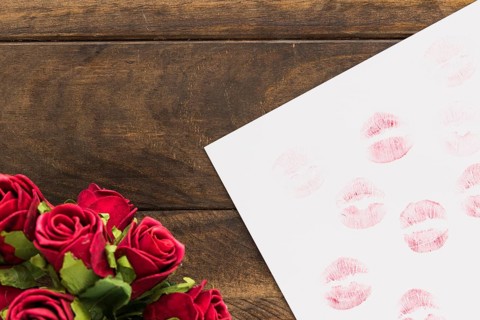 Lipstick kisses paper near beautiful flowers