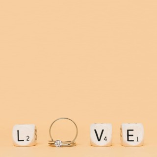 Love letter made with wedding diamond rings cubes cream background