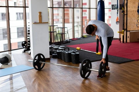 Man placing weight plates bar