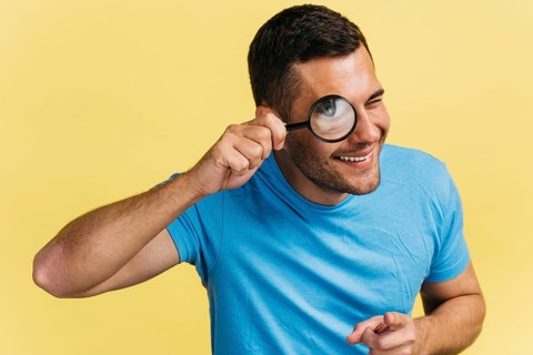 Man watching through magnifier