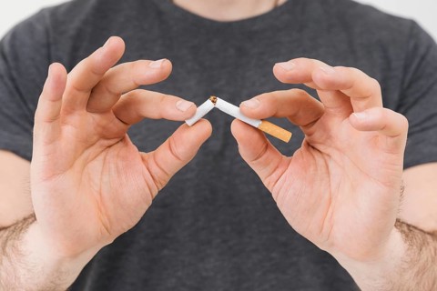 Mid section man s hand breaking cigarette