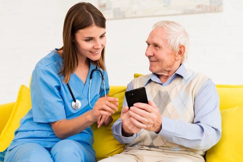 Old man showing s phone nurse