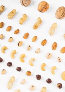 Overhead view walnuts peanuts almonds pistachios hazelnut cashew nuts white background
