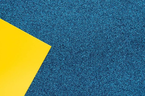 Overhead view yellow cardboard paper blue surface