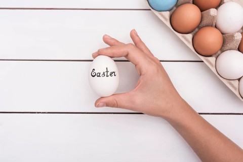 Person holding egg with easter inscription