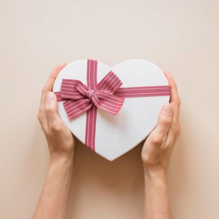 Person holding gift box heart shape