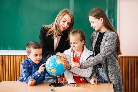 School teacher students working with globe