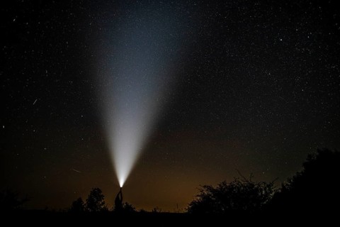 Shooting stars seen near flashlight held by man