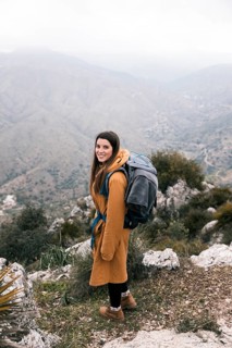Side view female hiker with her backpack hiking mountains