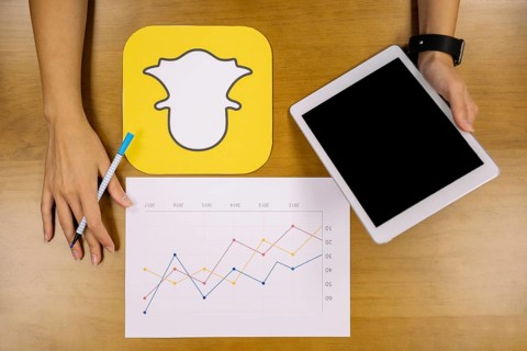 Social media planner analyzing snapchat graph with digital tablet