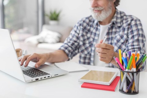 Teacher holding pen using laptop