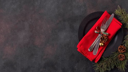Top view christmas table arrangement with pine cones cutlery