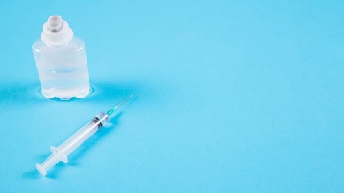 Transparent ampoules syringe blue backdrop