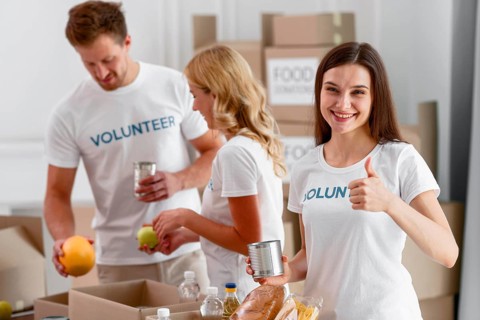 Volunteers helping with food donations giving thumbs up