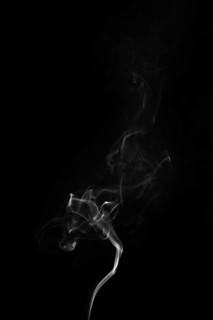 White smoke swirling around black background