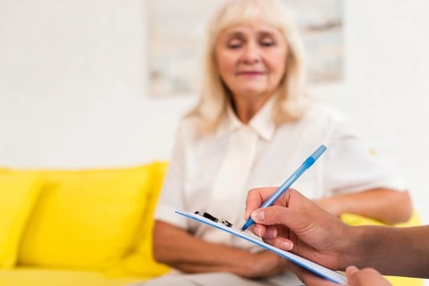 Caregiver writing clipboard close up