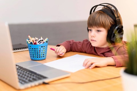 Child wearing headphones attending online school