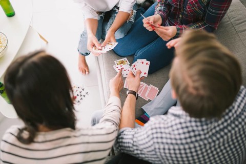 Chilling people playing cards sofa