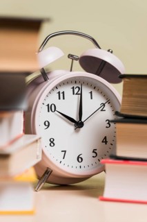 Close up alarm clock stacked books