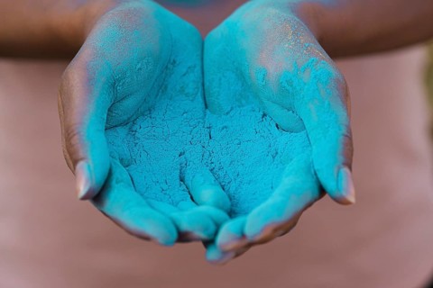 Close up hands holding blue powder