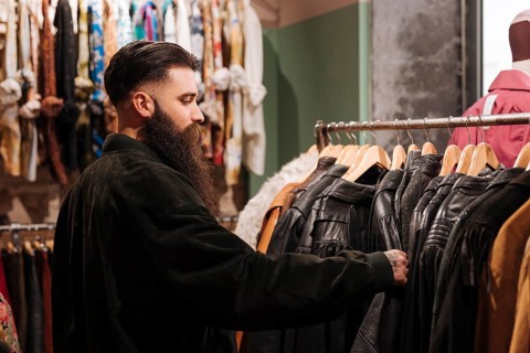 Close up man looking leather jacket rail clothing shop