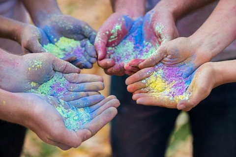 Close up multiple hands holding powder color