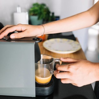 Close up woman taking coffee from coffee machine