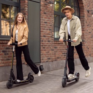 Couple using electric scooters outdoors