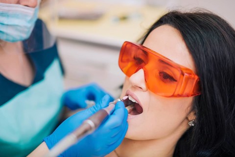 Dentist curing teeth patient glasses