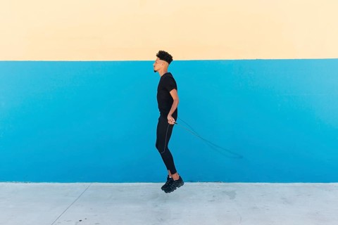 Ethnic man jumping rope street