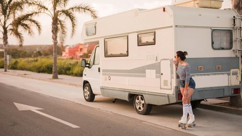 Female skater standing caravan road peeking
