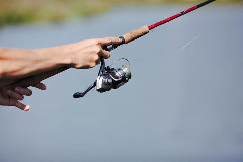 Fisherman s hand fishing blurred background