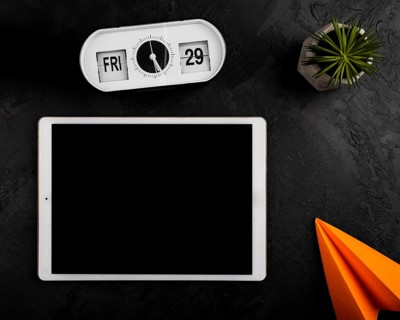 Flat lay tablet clock paper plane