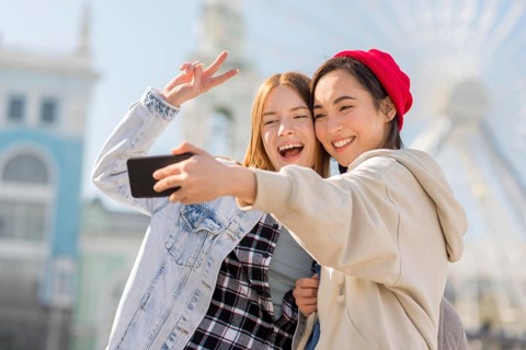 Girlfriends taking selfie with london eye