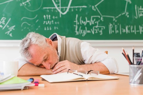 Grey haired teacher sleeping table
