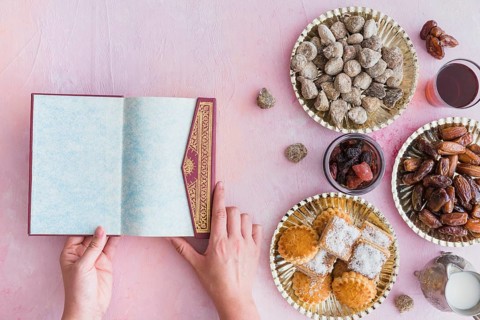 Hands with koran table with sweets