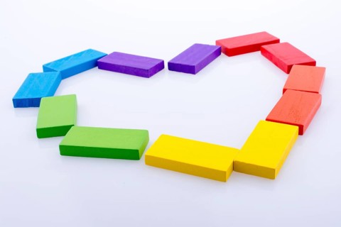 Colorful Domino Blocks forming a Heart on a white background