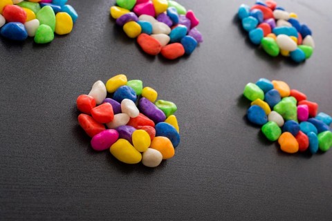 Pile of little colorful pebbles on black background