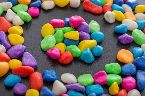 Pile of little colorful pebbles on black background