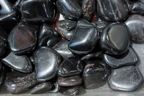 Shiny metallic gray tumbled hematite gemstone as mineral rock