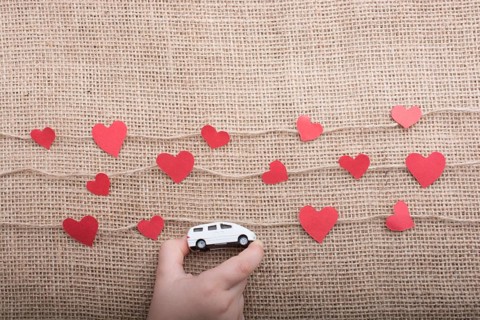 Love concept with car and paper heart on linen threads