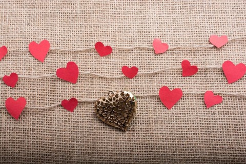 Love concept with heart shaped papers on linen threads